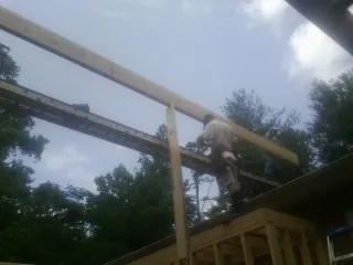 Carpenter setting a ridge beam over a new addition frame — Ice Dam Removal by Roofing Brothers in Central Valley