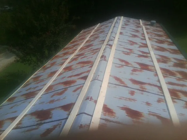 Rusted metal roof panels with new wood purlins before replacement — Storm Damage Roof Repair in Central Valley by Roofing Brothers