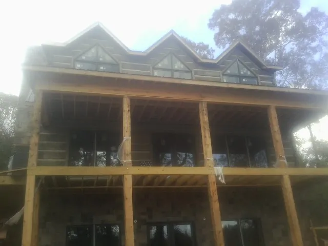 Dormers and porch framing on a large log home under construction — Roof Coating work by our crew in Central Valley
