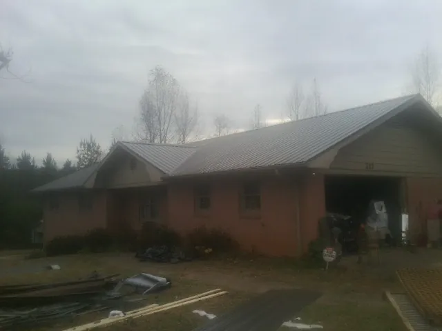 Gray metal roof on a stucco house with an attached garage in Central Valley