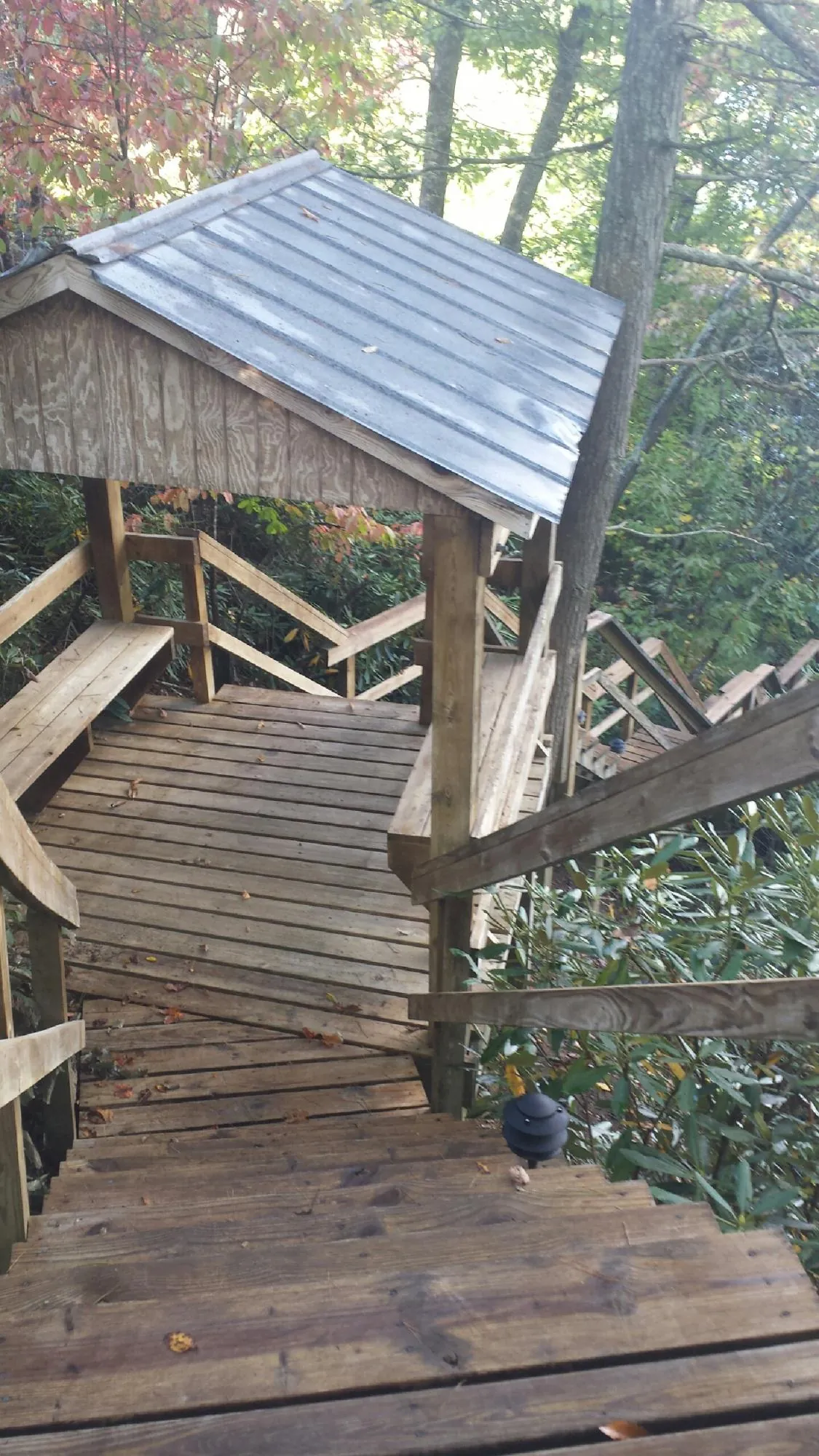 Metal roofed shelter over wooden steps on a wooded walkway — Skylight Repair & Installation work by our crew in Central Valley